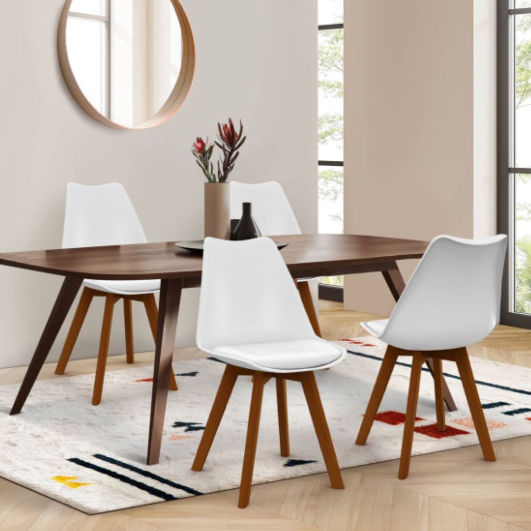 4 chaises blanches scandinaves autour d'une table en bois